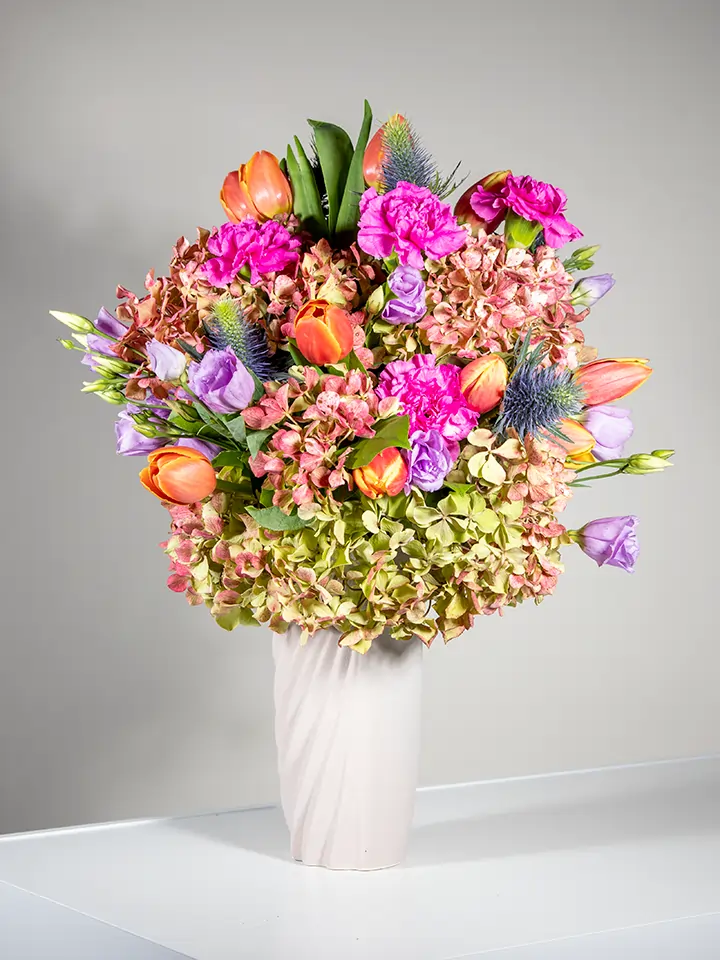 Bouquet con ortensia garofani tulipani eryngium in vaso